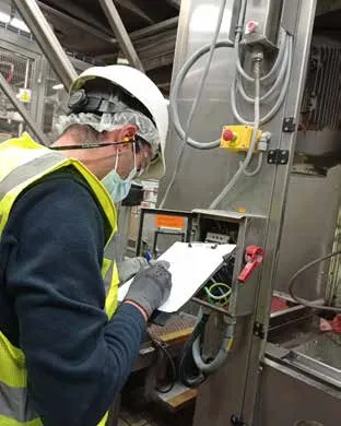 Técnico com EPI inspecionando uma chave de bloqueio CEFEM em campo